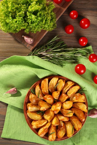 Baked potato wedges on wooden table, top view — Stock Photo, Image