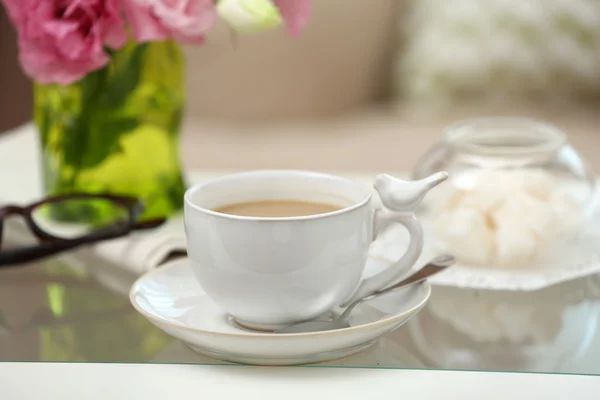 Cup of coffee on table in living room — Stock Photo, Image