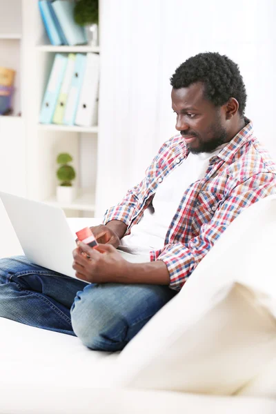 Hombre afroamericano con portátil y tarjeta de crédito en la habitación —  Fotos de Stock