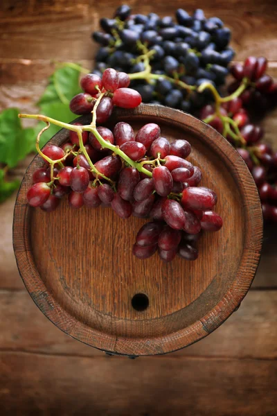 Barrica de vino viejo y uva sobre fondo de madera — Foto de Stock