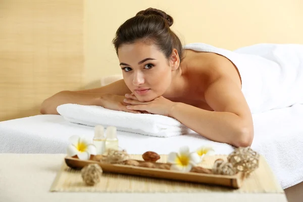 Mujer joven en la mesa de masaje en el salón de spa de belleza — Foto de Stock