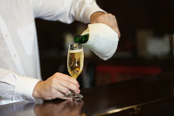 Bartender derramando champanhe em vidro — Fotografia de Stock