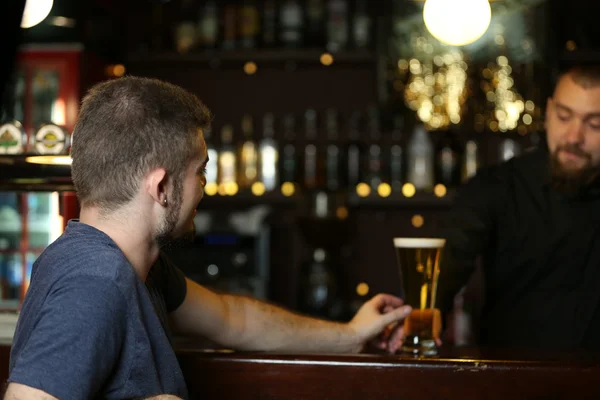 Giovane che beve birra al bar — Foto Stock