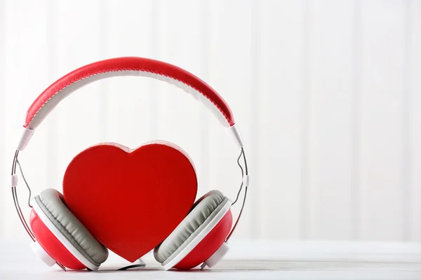 Rotes Herz mit Kopfhörer auf weißem Hintergrund — Stockfoto