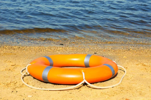 Une bouée de sauvetage sur une plage de sable — Photo