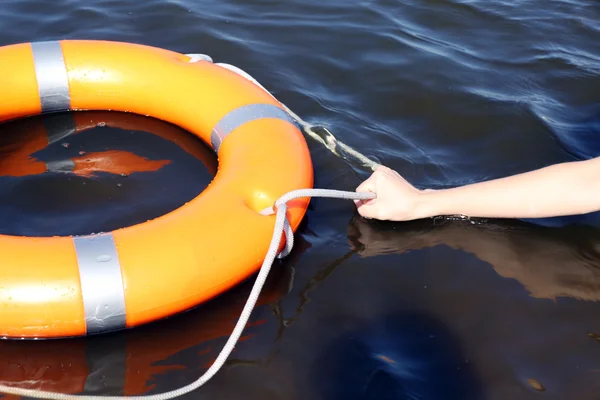 Hand holds a cord of a life buoy — Stock Photo, Image
