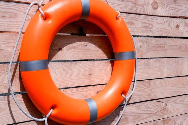 A life buoy on wooden background — Stock Photo, Image