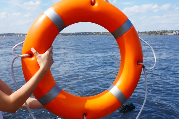 Le mani tengono una boa di salvataggio — Foto Stock