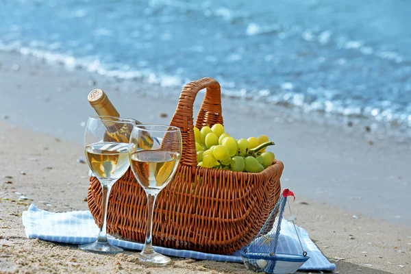 Cesta de piquenique com garrafa de vinho na praia de areia — Fotografia de Stock