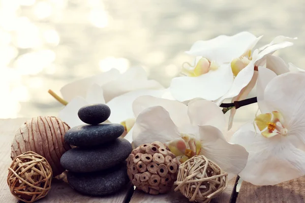 Set of pebbles and orchid on wooden background — Stock Photo, Image