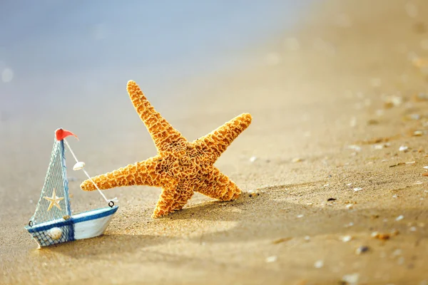 ヒトデ、浜辺の小さなボートのコンセプト — ストック写真