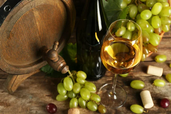 Uva blanca y roja con botella de vino cerca del barril — Foto de Stock