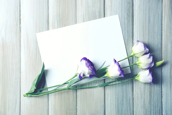 Composición de lámina blanca y flor sobre fondo de madera gris, espacio vacío —  Fotos de Stock