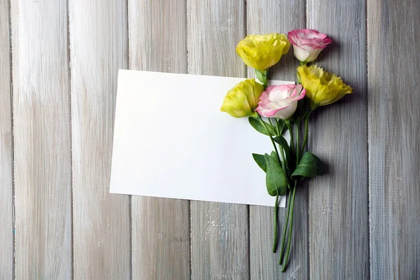 Composición de lámina blanca y flor sobre fondo de madera gris, espacio vacío —  Fotos de Stock