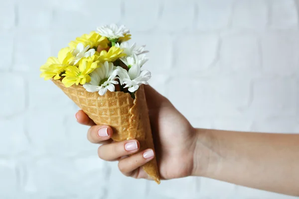 Vrouw hand met wilde bloemen in wafer — Stockfoto