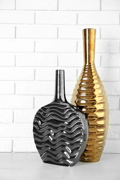 Beautiful vases on brick wall background — Stock Photo, Image