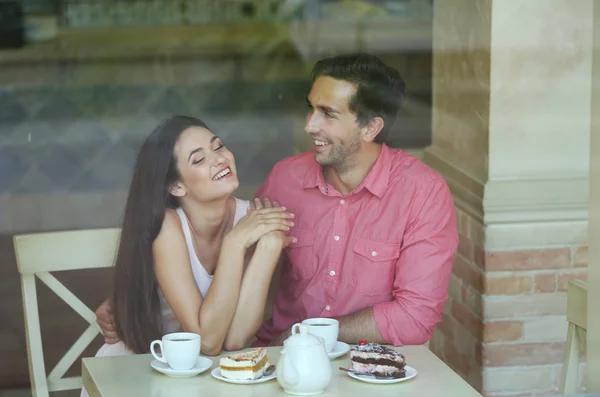 Young couple drinking tea and talking in cafe — Stock Photo, Image