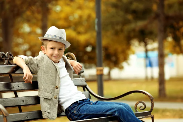 Petit garçon sur banc dans le parc — Photo