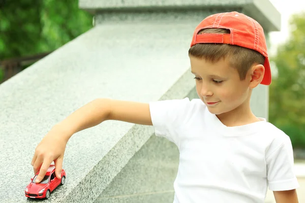 Niño jugando con coche de juguete afuera — Foto de Stock