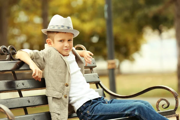 小男孩坐在公园长椅上 — 图库照片