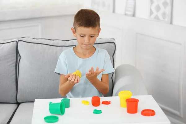 Lindo niño moldes de plastilina en la mesa — Foto de Stock