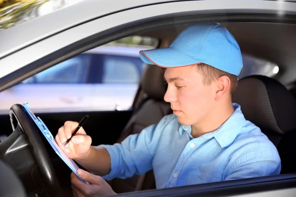 Pizza delivery boy with tablet in car, close-up — Stock Photo, Image