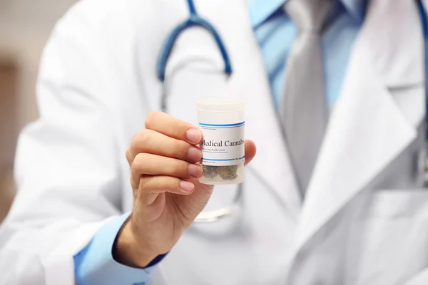 Doctor holding bottle with medical cannabis — Stock Photo, Image