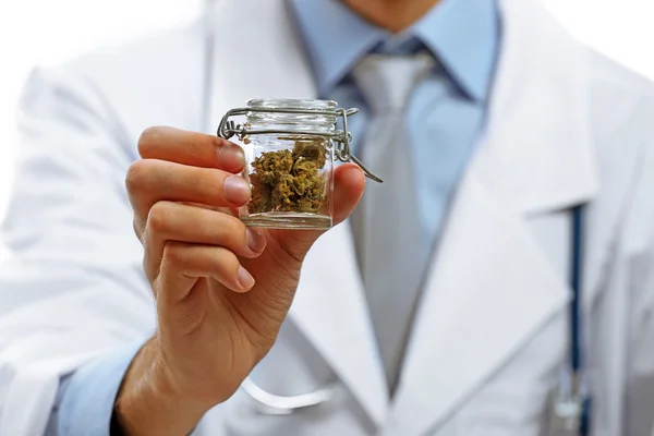 Médico segurando garrafa com cannabis medicinal — Fotografia de Stock