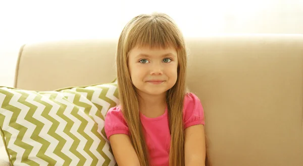 Gadis kecil yang cantik duduk di sofa — Stok Foto