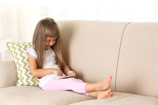 Ragazza con smart phone seduto sul divano — Foto Stock