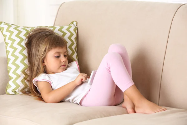 Девушка со смартфоном лежит на диване — стоковое фото