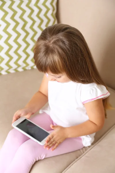 Fille avec téléphone intelligent assis sur le canapé — Photo