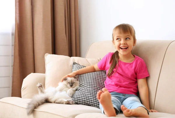 Mädchen mit Kätzchen auf Sofa — Stockfoto