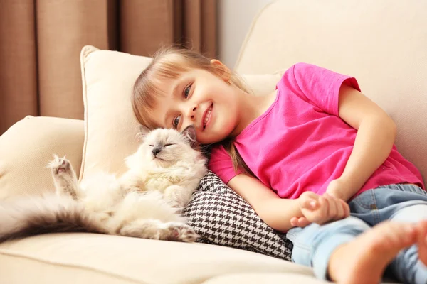 Flicka med kattunge på soffa — Stockfoto