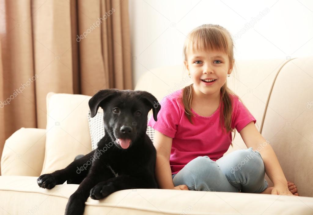 girl with puppy on sofa