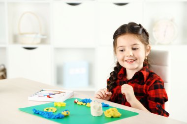 Masanın üzerindeki plastikten tatlı küçük kız kalıpları.