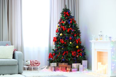 Oturma odasının altında hediyeler olan mükemmel bir Noel ağacı.