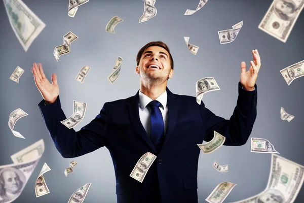 Biznesmen stojąc w deszczu pieniędzy — Zdjęcie stockowe