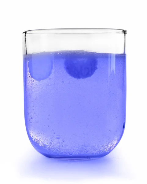Таблетки в стакане воды на светлом фоне — стоковое фото
