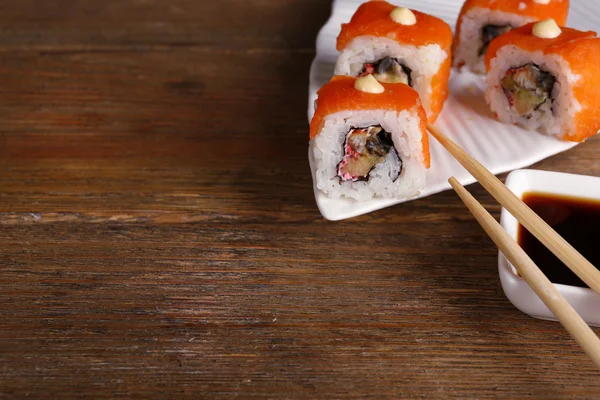 Rollos con salsa y palos en la mesa de madera de cerca — Foto de Stock