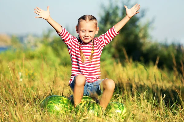 Menina pequena com melancias no gramado — Fotografia de Stock