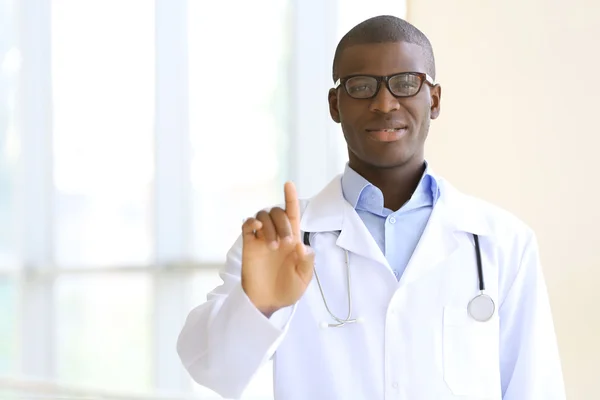 Bonito médico afro-americano com estetoscópio no hospital — Fotografia de Stock
