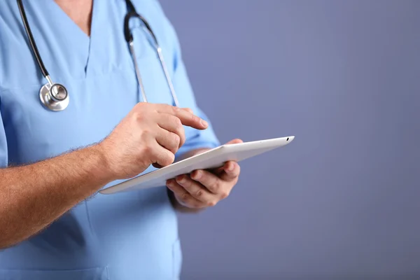 Médecin avec tablette numérique sur fond coloré — Photo