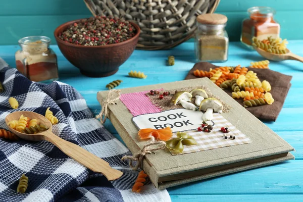 Zdobione książka kucharska na niebieskim tle drewniane — Zdjęcie stockowe