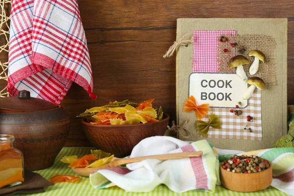 Украшенная композиция поваренной книги и кухонного оборудования на деревянном фоне — стоковое фото