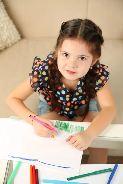 Cute little girl drawing picture on home interior background — Stock Photo, Image