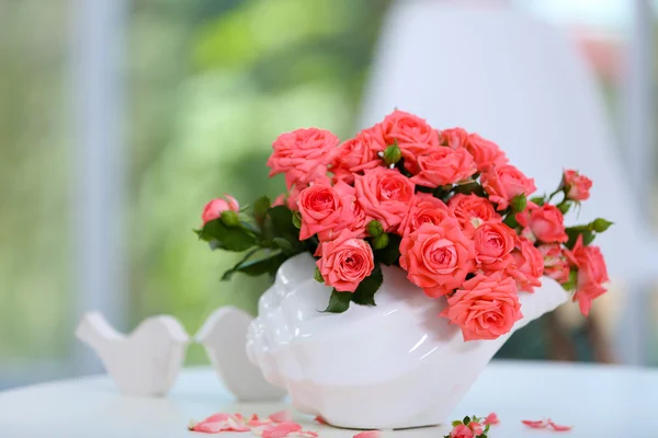 Bela rosa em vaso na mesa no quarto — Fotografia de Stock