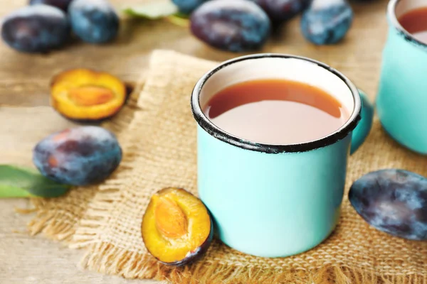 Plum Juice in mugs with fresh fruits — Stock Photo, Image