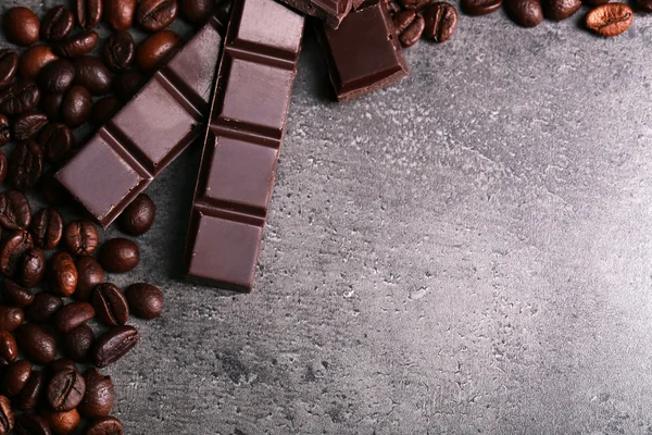 Koyu çikolata parçaları ve koyu gri arka plan üzerinde kahve taneleri — Stok fotoğraf