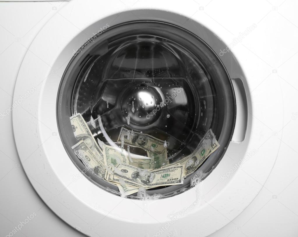 Laundering of dirty money in washing machine, close up